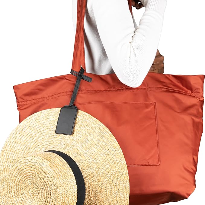 Stylish magnetic hat clip holder securing a straw hat to an orange bag, showcasing innovative design and strong TPE material.