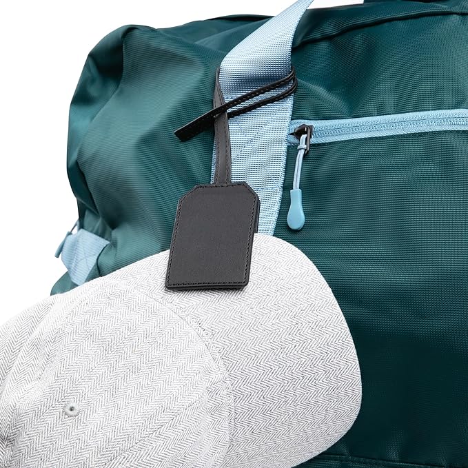 Magnetic hat clip holder securing a cap to a teal backpack, showcasing durable design and strong magnet for travel convenience.