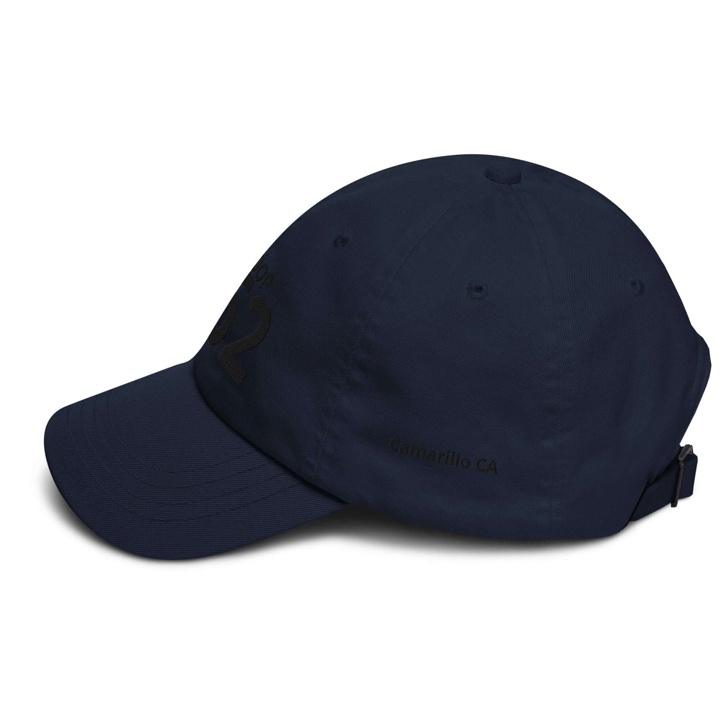 Navy blue low-profile hat with adjustable strap and curved visor, featuring embroidered details and six eyelets.