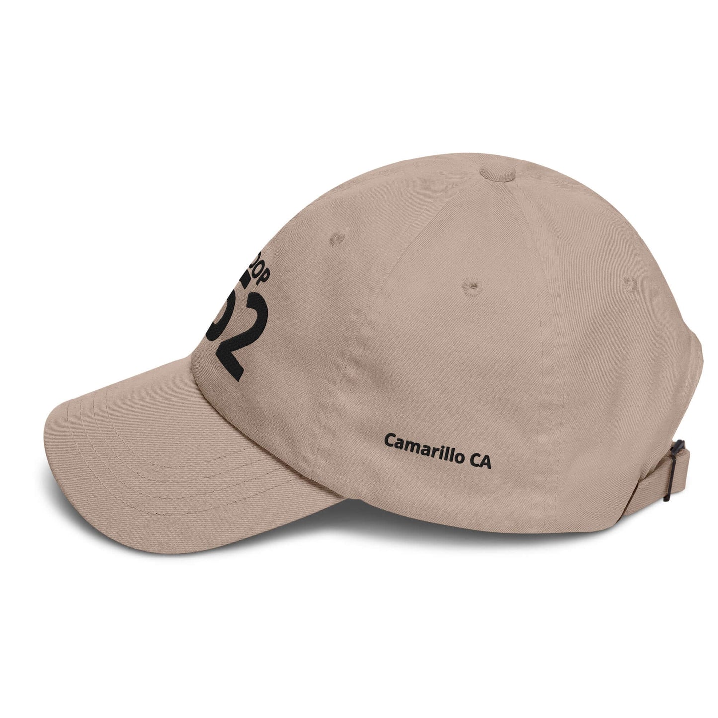 Beige low-profile cap with black print, adjustable strap, and curved visor, featuring "Camarillo CA" and identification number.